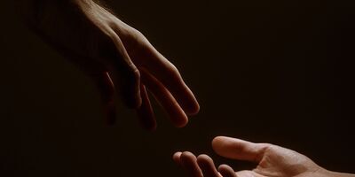 Two hands reaching to touch each other