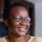 School of Fine Art, History of Art and Cultural Studies alumni, Laura Fungai Ganda. Laura is looking to the right of the frame and is smiling.